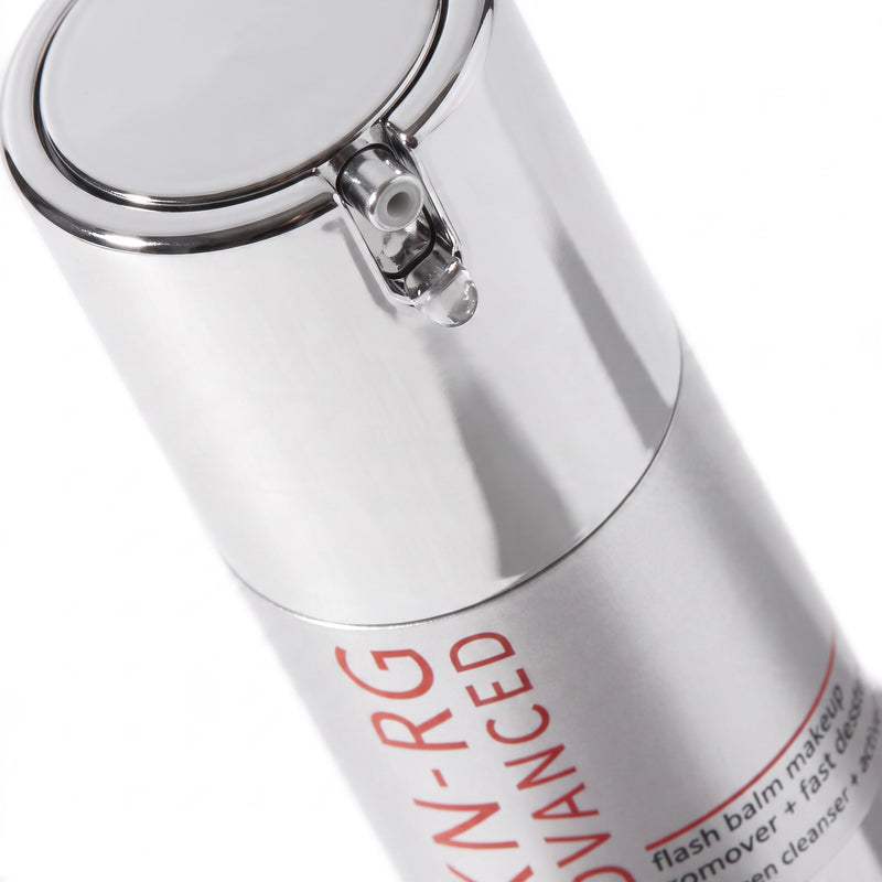 Close-up of a metallic silver cosmetic pump bottle with red text reading 'ADVANCED' and partial text 'flash balm makeup remover + fast. 