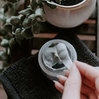 in jar texture shot of SKIN-RG Resurrection polish and mask in 1 skincare product jar on cloth with hand removing product with spatula
